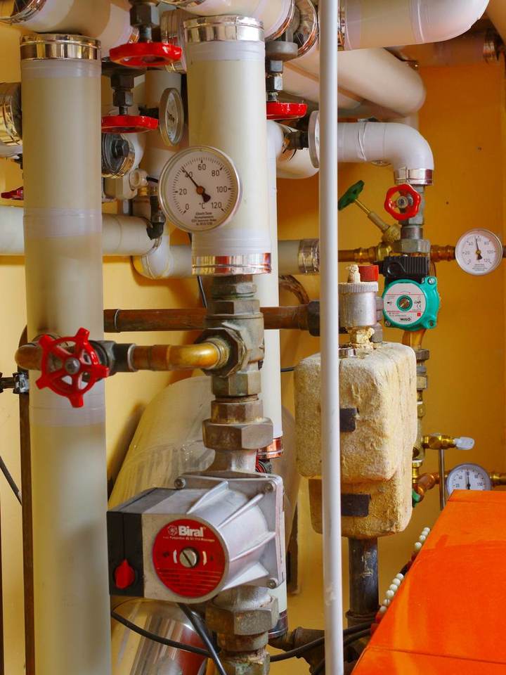 Heating system pipes, valves and pressure gauges in a mechanical room